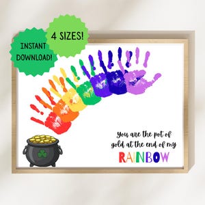 以下が含まれることがあります： 虹色の手形のデザインが施された額入りのプリントで、金のポットにつながっています。テキストは「You are the pot of gold at the end of my RAINBOW」と書かれています。緑色のスターバーストには「INSTANT DOWNLOAD!」と「4 SIZES!」と書かれています。