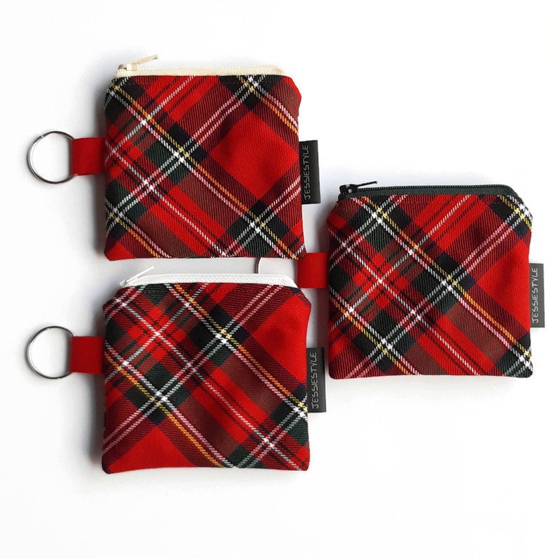 May include: Three red and black plaid zippered pouches with key rings. The pouches have white piping and a black label with the text "JESSIESTYLE".