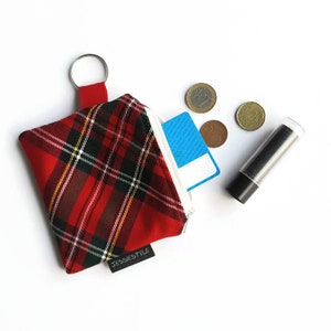 May include: Red and black plaid zippered pouch with a silver key ring. The pouch is open and contains a blue card, a few coins, and a clear tube of lip balm. The pouch has the text "JESSIESTYLE" on the bottom.
