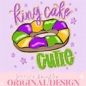May include: A digital illustration of a King Cake with purple, green, and yellow sections. The words "King Cake Cutie" are written in purple and green script with gold glitter accents. Small purple star shapes are scattered around the cake.