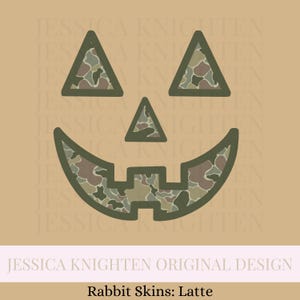 May include: A stylized jack-o'-lantern face with triangular eyes and a smiling mouth. The interior of the face is filled with a camouflage pattern in shades of green, brown, and tan. The text "JESSICA KNIGHTEN ORIGINAL DESIGN" and "Rabbit Skins: Latte" are at the bottom.