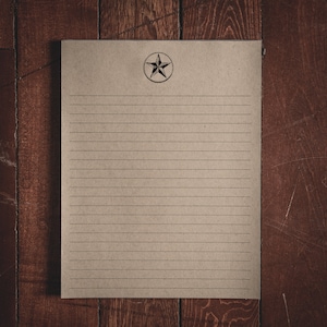 May include: A blank sheet of lined paper with a five-pointed star in a circle at the top. The paper is brown and has a rustic look.
