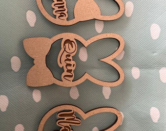 Peut inclure: Trois décorations en bois en forme de lapin avec les noms "Ayanna", "Quinn" et "Wajeeh" gravés dessus.