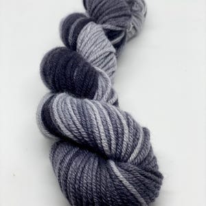 May include: A skein of yarn in a gradient of dark gray and light gray colors.