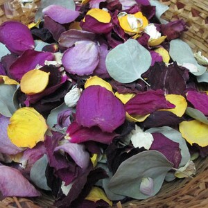 Puede incluir: Una cesta de mimbre llena de p&eacute;talos y hojas de flores secas. Los p&eacute;talos son de color p&uacute;rpura, amarillo y blanco, con algunas hojas de color verde gris&aacute;ceo. La cesta est&aacute; hecha de material tejido marr&oacute;n claro.