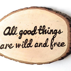 May include: A wooden slice with the text "All good things are wild and free" burned into the surface.