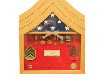 May include: A wooden shadow box with a red felt background and a glass front. The shadow box features a US flag, a set of military medals, and a nameplate that reads "Sgt Kevin D. Taggerty USMC 22 May 1996 - 30 May 1994".