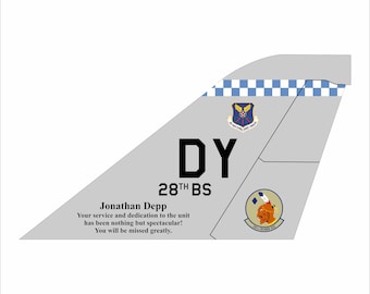 May include: A grey and white aircraft tail fin with the letters "DY" and the text "28TH BS". The tail fin also has a blue and white chequered pattern and two emblems. The text "Jonathan Depp Your service and dedication to the unit has been nothing but spectacular! You will be missed greatly." is printed below the tail fin.