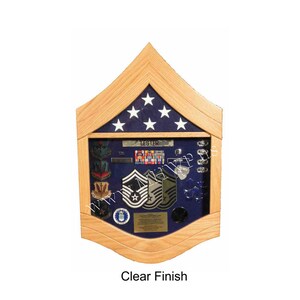 May include: A wooden shadow box with a blue background and a display of military medals, ribbons, and patches. The shadow box has a clear finish and the text "Lester" is visible on the top.
