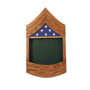 Puede incluir: Una caja de sombra de madera con un diseño de bandera estadounidense azul y blanca. La caja de sombra tiene un fondo de fieltro verde y está diseñada para guardar recuerdos militares.