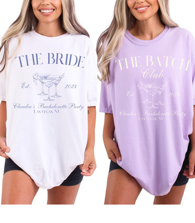 May include: Two oversized t-shirts, one white and one lavender, with text and graphics. The white shirt reads "THE BRIDE" above a cocktail graphic and "Claudia's Bachelorette Party LAS VEGAS, NV." The lavender shirt says "THE BATCH Club" with similar design elements.