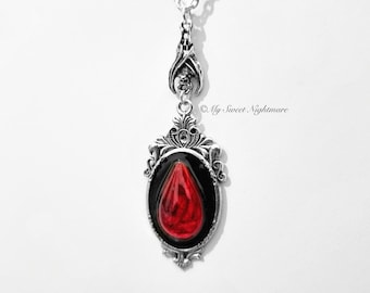 Colar com pingente cabochão com efeito de sangue e morcego.
