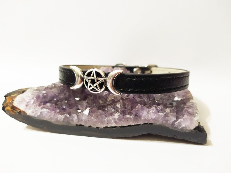 May include: Black leather choker with a silver triple moon and pentagram charm.