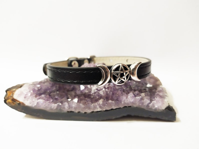 May include: A black leather choker necklace with a silver triple moon and pentacle charm.