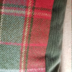 Puede incluir: Coj&iacute;n de tiro de cuadros rojos, verdes y beige con un borde de terciopelo verde oscuro.