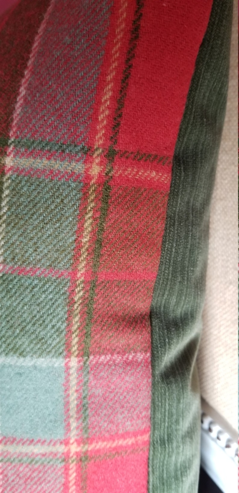 Puede incluir: Coj&iacute;n de tiro de cuadros rojos, verdes y beige con un borde de terciopelo verde oscuro.