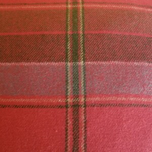 Puede incluir: Coj&iacute;n de tiro de color rojo, verde y beige a cuadros con una textura suave y peluda.