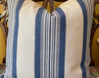 May include: A blue and white striped throw pillow with a subtle woven texture. The pillow is shown on a wooden chair with a plaid fabric.