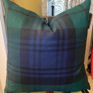 May include: A green and blue plaid throw pillow with a square shape. The pillow is made of a soft, woven fabric.