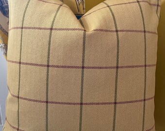 May include: A yellow and brown plaid throw pillow with a subtle herringbone pattern. The pillow has a red and green plaid design.