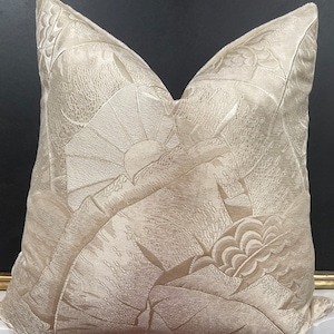 May include: A cream-colored throw pillow with an embossed floral pattern. The pillow is made of a soft, luxurious fabric and has a subtle sheen.