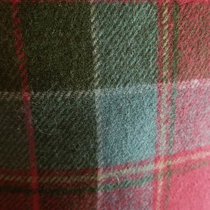 Puede incluir: Primer plano de una tela de cuadros rojos, verdes y blancos. La tela tiene una textura suave y peluda.