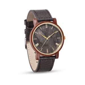 May include: A brown wooden wristwatch with a black face and gold Roman numeral hour markers. The watch has a brown leather strap.