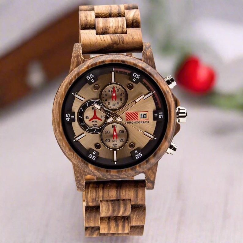 May include: A brown wooden wristwatch with a gold face and black chronograph dials. The watch face has white markings and the text "CHRONOGRAPH" and "18".