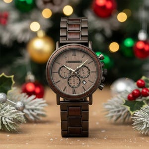 May include: A wooden wristwatch with a brown face and band. The watch features three sub-dials and Roman numeral hour markers. The watch is set against a festive background with Christmas ornaments.