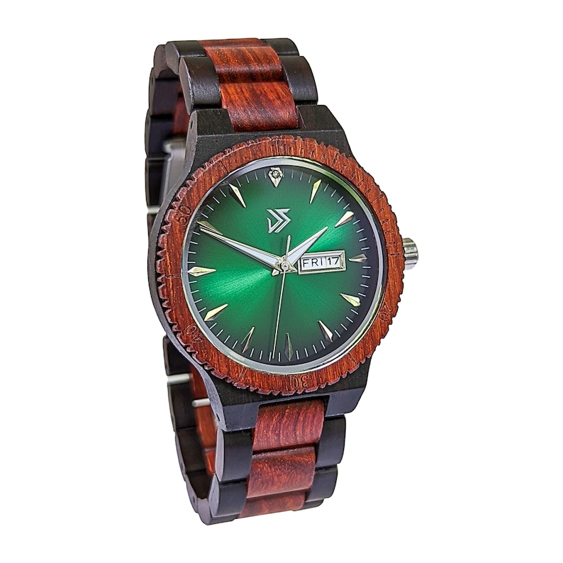 Peut inclure: Une montre-bracelet avec un cadran vert et un bracelet en bois noir et rouge. Le cadran de la montre pr&eacute;sente une aiguille des heures et des minutes argent&eacute;e, une fen&ecirc;tre de date affichant "FRI 17" et un marqueur en forme de diamant &agrave; la position 12 heures.
