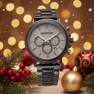 May include: A wooden-faced chronograph watch with a dark brown metal band. The watch face has three sub-dials and a date window. The background features Christmas ornaments and lights, creating a festive holiday theme.