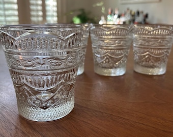 Può includere: Set di quattro bicchieri trasparenti con motivi. Ogni bicchiere presenta un intricato design di motivi floreali e geometrici ripetuti. I bicchieri sono in vetro trasparente e sono adatti per acqua, succhi di frutta o cocktail.