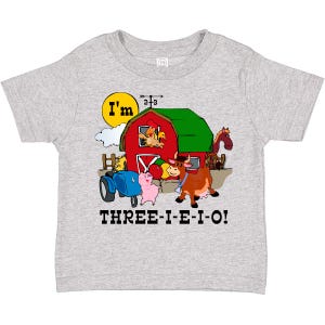 May include: A light gray toddler t-shirt featuring a colorful farm scene. The design includes a red barn, a blue tractor, and cartoon animals. Text on the shirt reads "I'm" and "THREE-I-E-I-O!"
