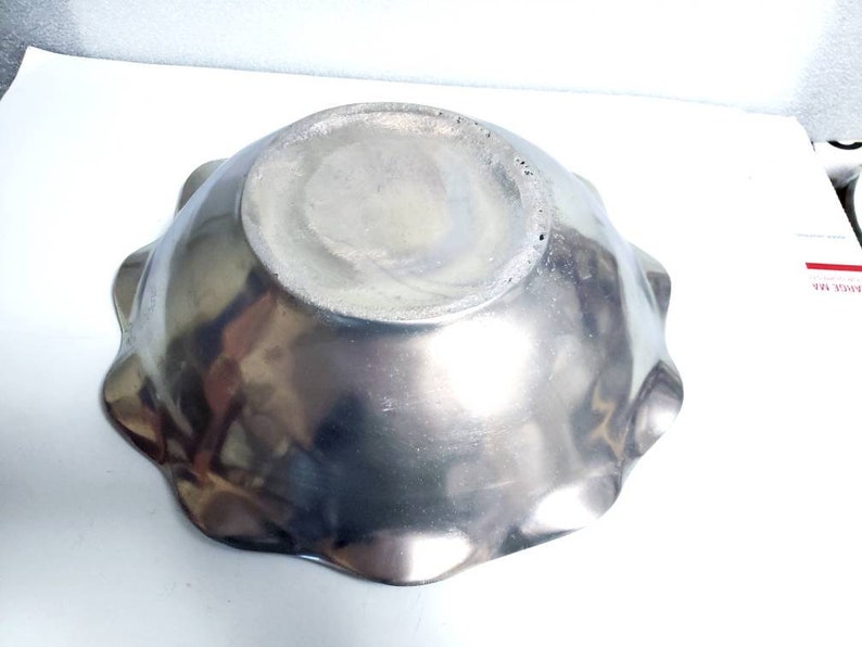 Peut inclure: Un bol en m&eacute;tal argent&eacute; avec un bord festonn&eacute;. Le bol est vide et a une surface brillante et r&eacute;fl&eacute;chissante.