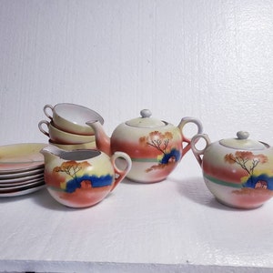 May include: A vintage tea set with a delicate floral design. The set includes a teapot, creamer, sugar bowl, and four cups and saucers. The tea set is painted with a yellow, orange, and blue floral pattern.