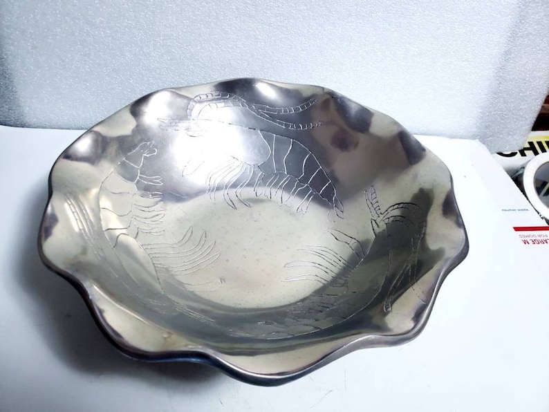 Peut inclure: Un bol de service en argent avec un bord festonn&eacute; et un motif en relief de crevettes.