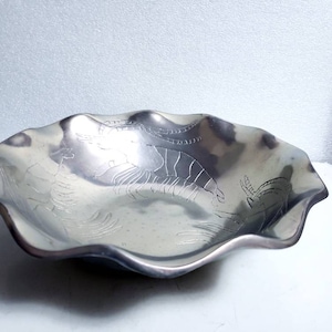 Peut inclure: Un bol de service en argent avec un bord festonn&eacute; et un motif de crevettes en relief. Le bol est en m&eacute;tal et a une finition brillante.