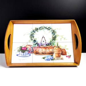 May include: Wooden serving tray with a decorative floral tile insert. The tile features a watercolor painting of a birdhouse, flowers, and a wreath. The tray has two handles and a light wood finish.
