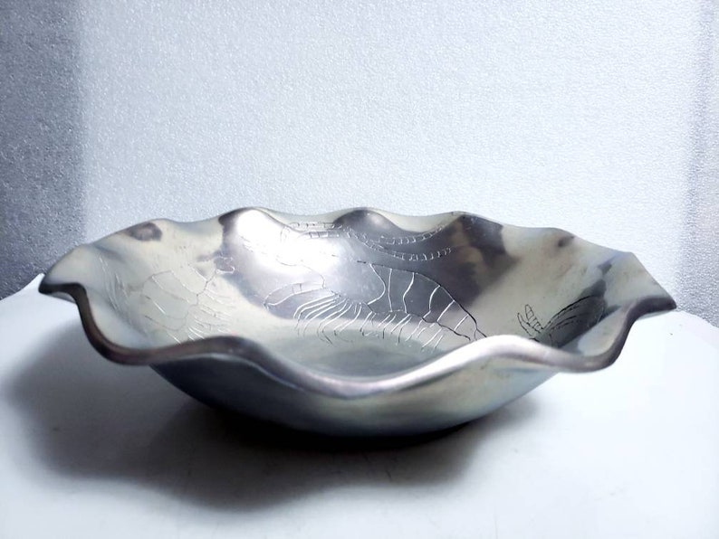 Peut inclure: Un bol de service en argent avec un bord ondul&eacute; et un motif en relief de homards.