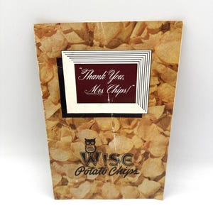 May include: A vintage Wise Potato Chips paper bag featuring a background of golden-brown potato chips. The center displays a maroon rectangular box with the white text "Thank You, Mrs. Chips!" and a small owl logo above the brand name text.