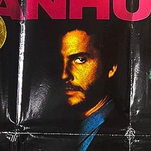 Puede incluir: Cartel de película vintage de "Manhunter" con título rojo. El cartel presenta dos rostros de hombres, uno de perfil y otro en primer plano. El texto incluye un eslogan y la fecha de estreno de la película.