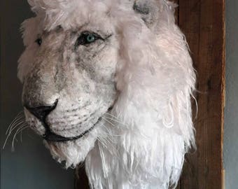 May include: White lion head sculpture made of paper mache, mounted on a wooden plaque. The sculpture has a realistic appearance with detailed fur and a blue eye. The plaque has the text "DEEP RIVER ART by Kim" on it.
