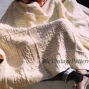 Pode incluir: Cobertor de malha creme com uma variedade de padr&otilde;es quadrados texturizados. O cobertor tem uma borda com franjas e est&aacute; sobre algu&eacute;m. O texto "Chic Vintage Patterns" &eacute; vis&iacute;vel.