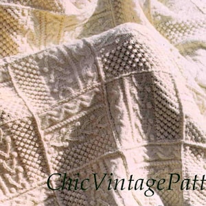 Pode incluir: Cobertor de malha com padr&otilde;es intrincados de cor creme. O cobertor apresenta uma variedade de quadrados texturizados com tran&ccedil;as, losangos e outros desenhos decorativos. O texto "Chic Vintage Patterns" &eacute; vis&iacute;vel no canto inferior direito.
