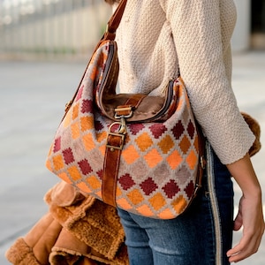 Chenille bag printed with geometric motifs in orange, brown and gray tones.
Double closure, with zipper and carabiner make it a bag / backpack, very safe.
Velvety leather handles in dark honey color.
Soft and supple bag. Lightweight and comfortable.