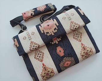 May include: A black and white patterned laptop bag with a flap closure. The bag has a long adjustable strap and a smaller matching pouch.