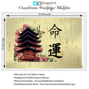 May include: A rectangular custom guitar skin measuring 24 inches wide by 16 inches high. The design features a multi-tiered pagoda, pink cherry blossoms, and black Japanese kanji characters on a light beige background with vertical gold streaks.
