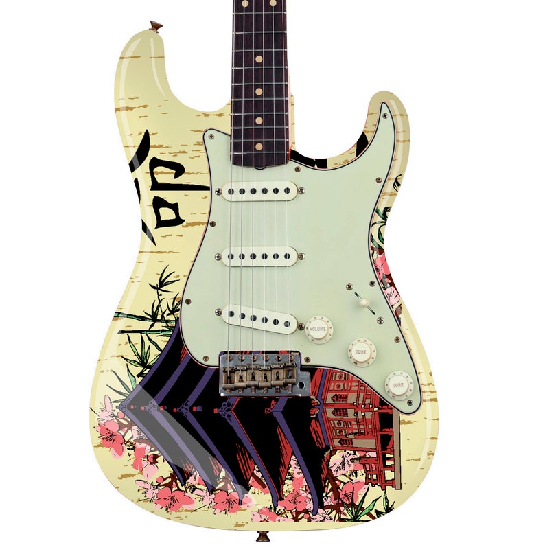 May include: An electric guitar with a cream-colored body featuring a graphic print of a traditional Japanese temple, bamboo stalks, and pink cherry blossoms. The guitar has a light green pickguard, three white single-coil pickups, and knobs.