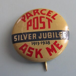 May include: A vintage round button with the text "PARCEL POST SILVER JUBILEE 1913-1938 ASK ME" in red and navy blue on a tan background. The button has a pin on the back.