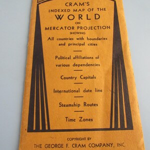May include: Vintage Cram's Indexed Map of the World on Mercator Projection. The cover is a mustard yellow with black text and graphics. The map shows countries, boundaries, cities, political affiliations, and more. The price is 35¢.